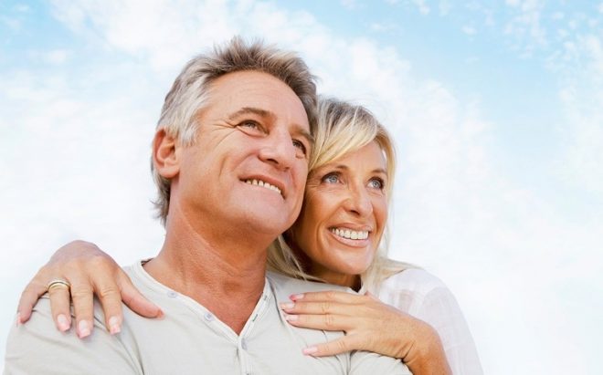 sorriso-impianti Coppia sorridente di mezza età all’aperto