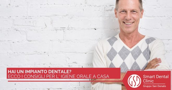 consigli-igiene-orale-impianto Uomo sorridente in primo piano con le braccia conserte