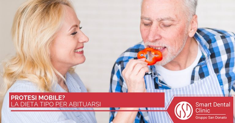 Coppia sorridente: uomo con protesi mobile morde un peperone rosso