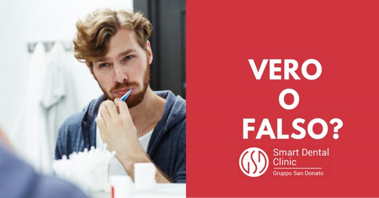 ragazzo che si lava i denti con lo spazzolino manuale guardandosi allo specchio